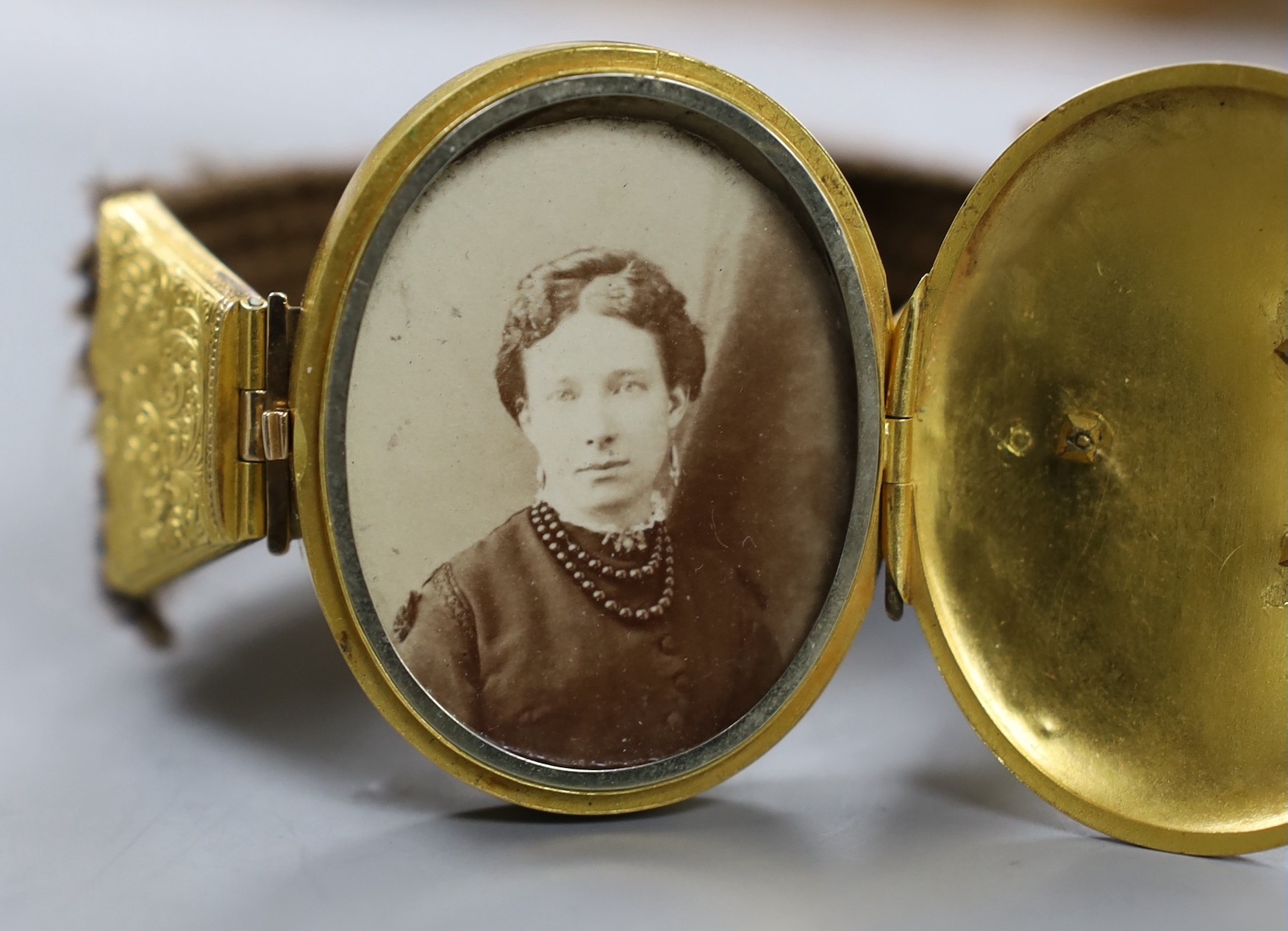 A Victorian yellow metal and hairwork bracelet with central photographic locket, central motif 44mm, gross weight 35.3 grams.